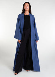 Waist pleats create a flowy silhouette, accompanied by wide sleeves and a stylish kimono style. The denim blue color adds to its overall appeal, while pockets provide functionality.