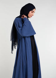 Waist pleats create a flowy silhouette, accompanied by wide sleeves and a stylish kimono style. The denim blue color adds to its overall appeal, while pockets provide functionality.