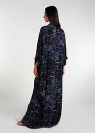 Designed with a modest, loose-fitting silhouette, this shirted kaftan is ideal for your summer wardrobe and holiday attire. The garment features buttons all the way down and is even suitable for nursing. You can also style it with your own belt to cinch in at the waist. Colour is dark navy blue with graphic abstract print of lines.